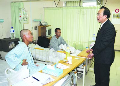 驻福冈总领事馆首席领事郭宝忠（右）昨慰问盐城籍获救船员纪长丰（左）和无锡籍的耿文磊。新华社发