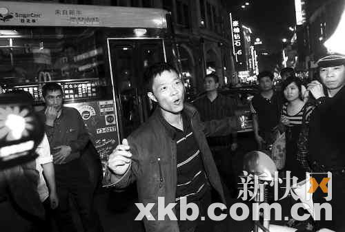 当救护车到达现场后，男子（中）突然爬起来，声称自己"被几万人迫害"。