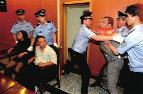 肇事司机张文明在法庭上情绪激动，他的妻子和大舅哥也分别被控制。本报通讯员李倩摄 