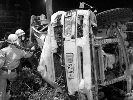 渣土车侧翻于安全岛中间的绿化带上，电线杆嵌入了渣土车的驾驶室内  