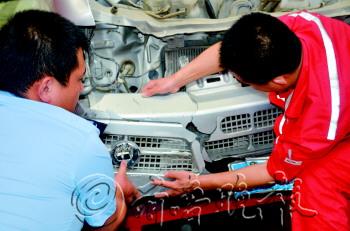 民警在比对肇事车。　本报记者　张焜　摄